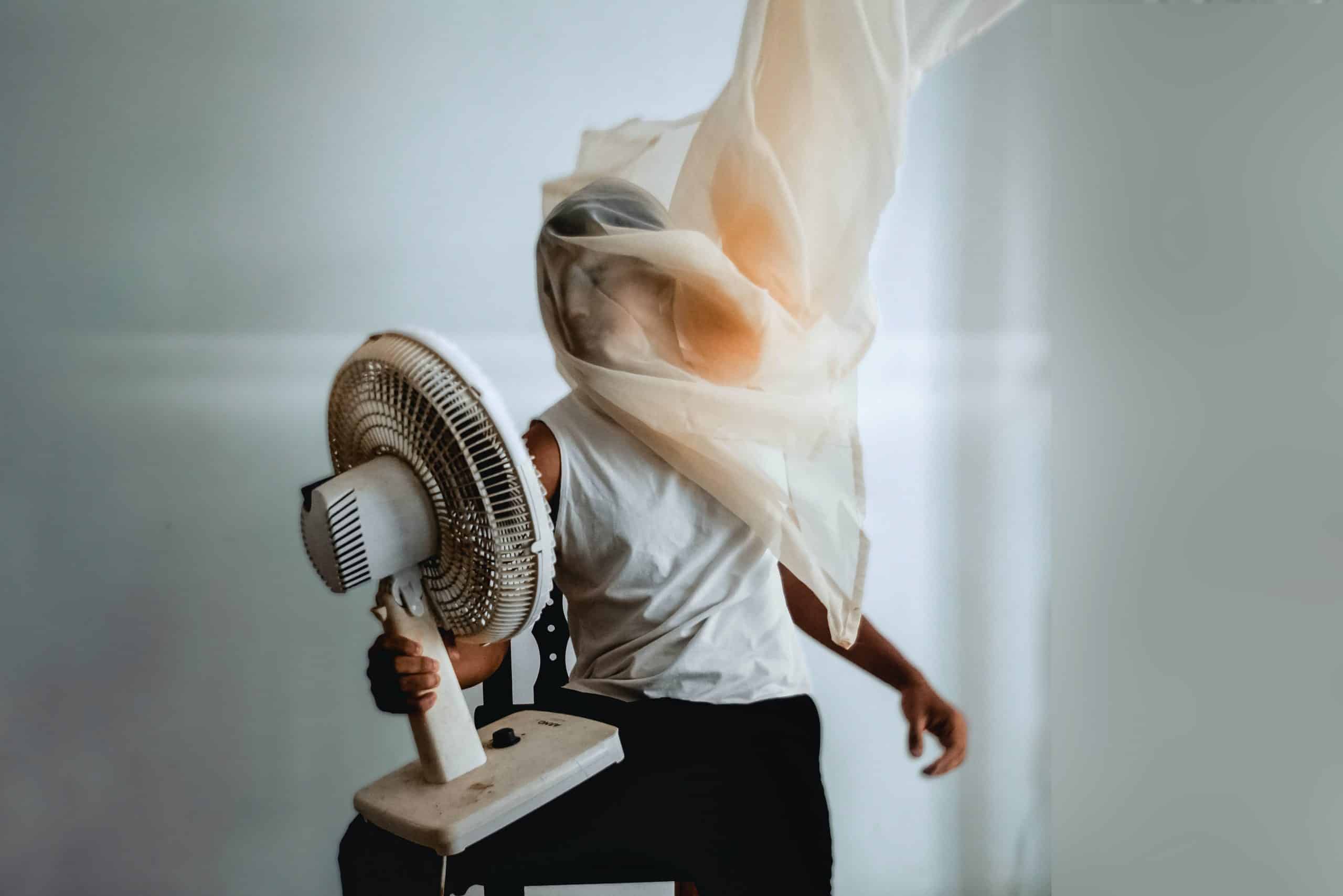 Un homme utiliser un ventilateur pour faire circuler l'air chaud de sa maison